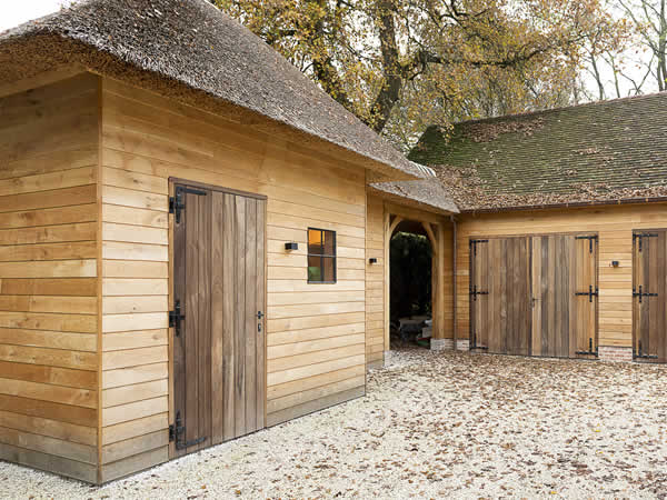 Landelijke houten bijgebouw met eiken binnenafwerking ontworpen en gebouwd door De Meyer houtbouw Evergem.