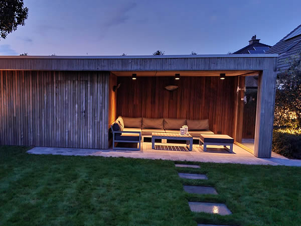 Poolhouse met berging in hout en terrasoverkapping in tuin door De Meyer Oost Vlaanderen