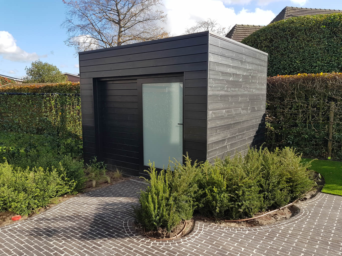 Tuinberging zwart hout modern met glazen deur in tuin voor klant uit Lievegem