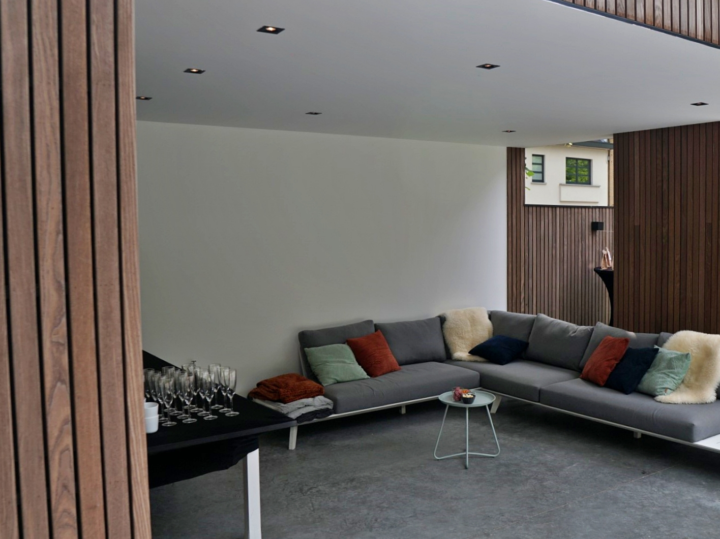 Terras van moderne poolhouse in padoek aangekleed met meubelen en bar regio Gent
