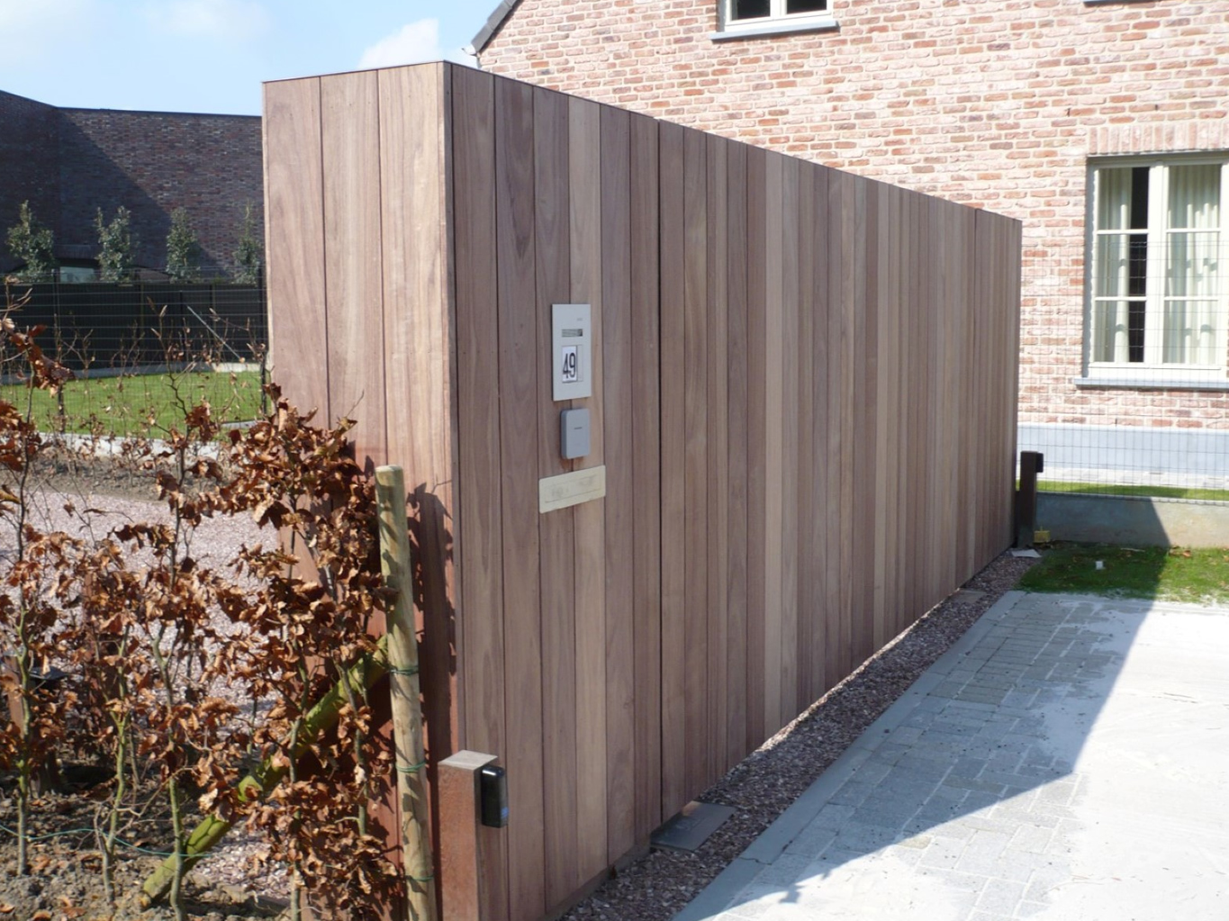 Moderne houten poort oprit met ingebouwde bel en automatisatie voor klant uit Oost Vlaanderen